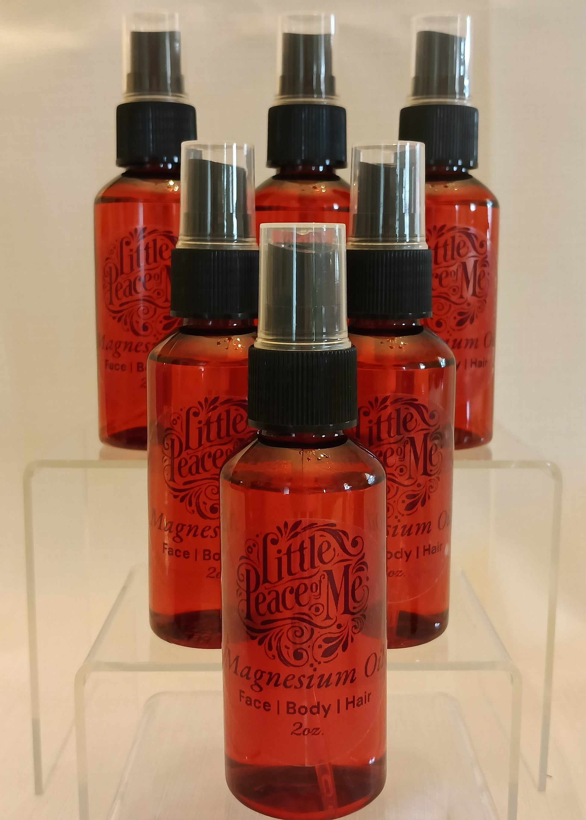 2oz clear spray bottle labeled magnesium spray, placed on a neutral background