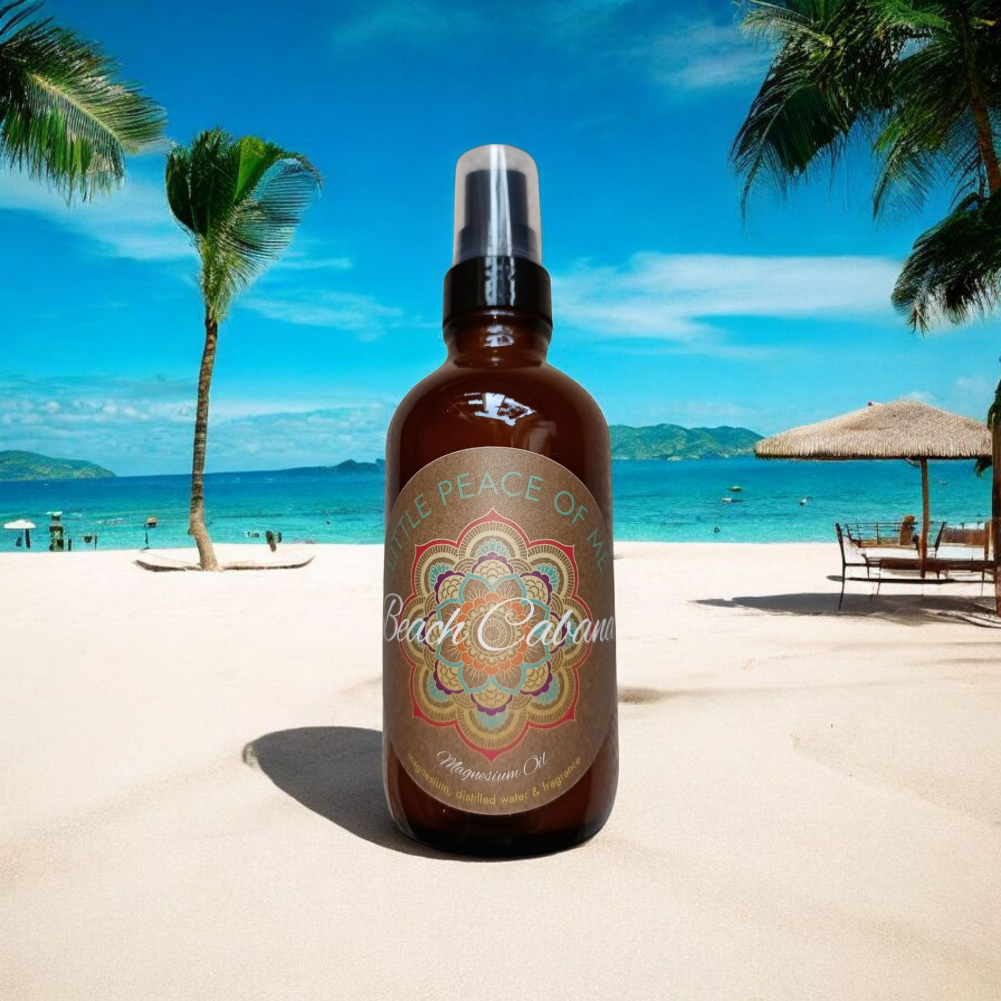 4 oz Boston dark spray bottle with a tin label that reads Little piece of Me beach Cabana magnesium will zoomed in on a beach setting where there's palm trees coming out in the very back middle is the ocean above that is skyview off to the other side is a palm tree with a Cabana in the backdrop sitting in the sand